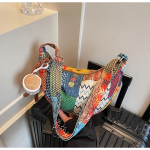 Dettaglio borsa patchwork etnica con motivi floreali e ciondolo a cuore