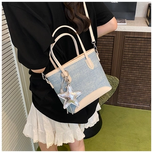 Vue détaillée du mini sac cabas en denim avec étoile et garniture en cuir beige