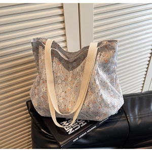 Detailed close-up of white floral lace overlay on a spacious fabric tote bag with woven handles