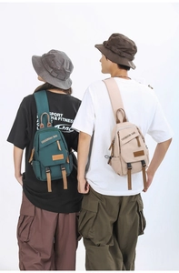 Rear view of models wearing durable dark green and beige crossbody sling bags for travel