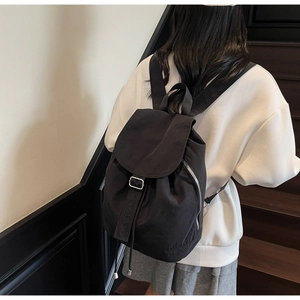 Vue arrière d'un sac à dos en nylon noir imperméable sur un modèle pour le quotidien