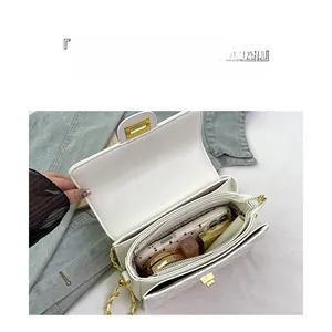 Macro view of white quilted chain bag showing interior storage for phone and cosmetics