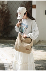 Detail of khaki oxford crossbody bag with flap pocket and durable canvas texture