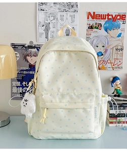 Detail of cream canvas backpack with blue star patterns and plush cloud pendant charm