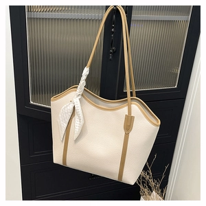 Detail of off-white tote bag with lychee texture leather and decorative silk scarf