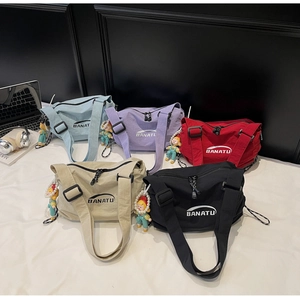 Collection of nylon dumpling bags in five colors with wide straps and cute charms