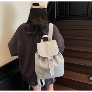 Détail du sac à dos en nylon imperméable avec rabat et poche latérale à fermeture éclair