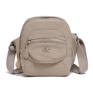 Détails d'un sac bandoulière en nylon beige avec fermetures éclair multicouches et logo en métal