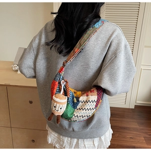 Dettaglio della borsa a tracolla patchwork etnica in tela con tracolla larga e ciondolo