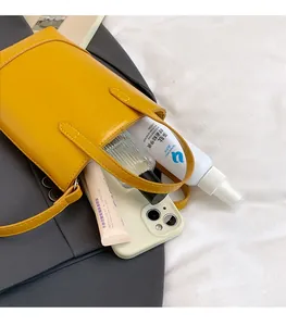 Detailansicht einer gelben Mini-Tote-Bag aus Leder mit Platz für Handy und Kosmetikartikel