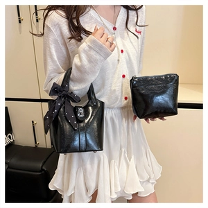Dettaglio del set borsa a secchiello nero lucido con sciarpa a pois e mini pochette