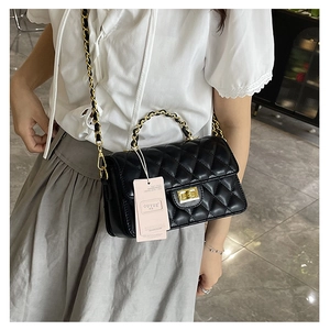 Detailed close-up of black quilted rhombus crossbody bag with gold chain strap