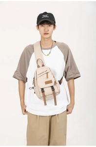 Front view of beige canvas chest bag worn by male model for casual outdoor travel