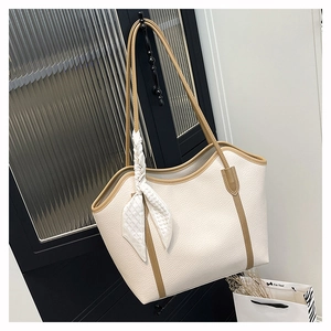 Detailed view of white lychee texture tote bag with brown straps and floral silk scarf decor