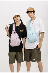 Couples wearing stylish lavender and light blue nylon crossbody bags for travel and leisure