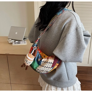 Dettaglio della borsa a mezzaluna patchwork colorata con un grazioso ciondolo a tazza di caffè
