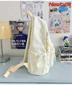 Detail view of canvas backpack side pocket with blue star pattern on white fabric