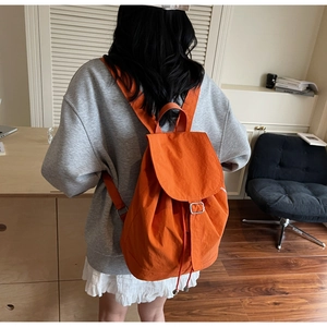 Détail du sac à dos étanche orange en nylon avec fermeture à cordon et boucle argent