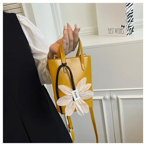 Nahaufnahme gelbe Eimertasche mit großer weißer Tüllblume und verstellbarem Riemen