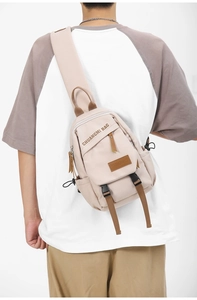 Detail of beige canvas chest bag featuring adjustable brown strap and buckle closure