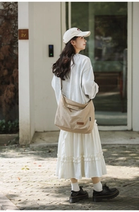 Detail of khaki water-resistant nylon messenger bag with adjustable strap and leather patch