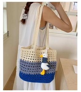 Close-up of tricolor woven crochet tote bag with textured knit pattern and plush charm