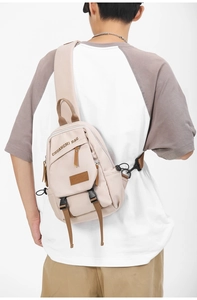 Close-up of light beige nylon chest bag with functional buckles and multiple compartments