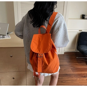 Détail du sac à dos orange étanche avec boucle métallique réglable et fermeture à cordon