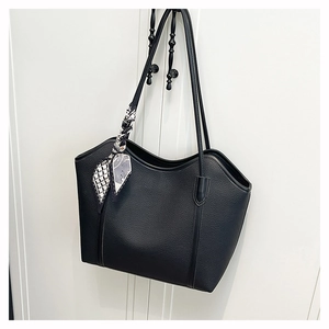 Close-up of black lychee grain leather tote bag with a decorative geometric print silk scarf