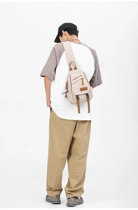 Model wearing a beige sports chest bag with brown accents and black text details