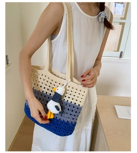 Detailed view of three-color gradient woven tote bag with cute duck charm and hollow texture
