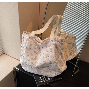 Detailed close-up of a white floral canvas tote bag with pink and blue flower patterns