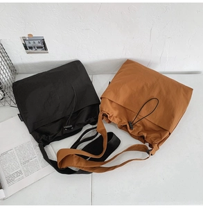 Detail of nylon drawstring bucket bags with pleated texture in black and brown colors