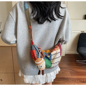 Dettaglio della borsa a tracolla patchwork bohémien a mezzaluna con un ciondolo di peluche