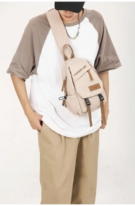 Close-up of beige canvas crossbody bag with multi-pocket design and adjustable strap