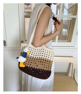 Detail of a tricolor gradient crochet tote bag with a hollow knit texture and duck charm