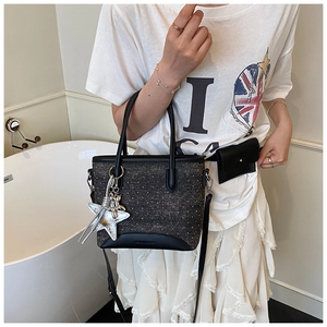 Détail du sac cabas en tweed gris avec poignées en cuir et pendentif étoile argenté