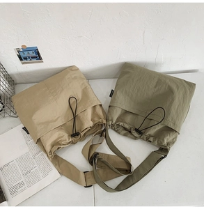 Macro detail of nylon drawstring bucket bags in khaki and army green with wide straps