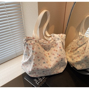 Detail of floral canvas tote bag with white lace embroidery and cotton ribbon handles
