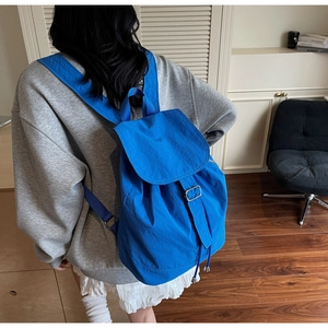 Vue arrière d'un sac à dos bleu roi imperméable avec fermeture à rabat sur un sweat