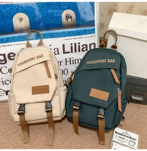 Detail view of canvas backpack texture featuring leather label and buckled flap cover