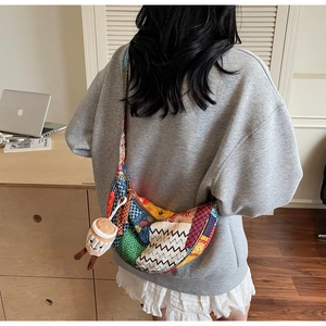 Dettaglio della borsa hobo patchwork colorata con motivi misti e ciondolo a tazza di caffè