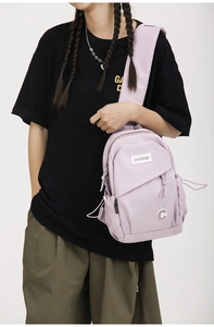 Detail view of a light purple nylon crossbody chest bag with adjustable strap on model