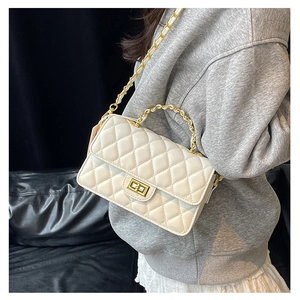 Detail of cream quilted chain bag with gold ring handle and square metallic twist lock