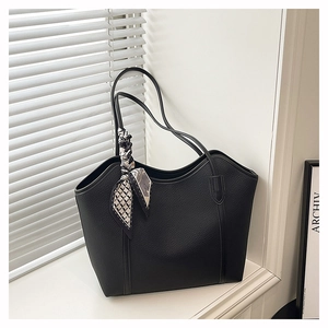 Close-up of large black tote bag with lychee texture and geometric pattern silk scarf