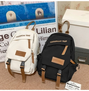 Detail of mini crossbody sports bags in black and beige with leather accents and buckles