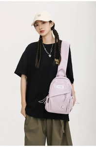 Close-up of light purple crossbody bag showing pockets, drawstring details and logo