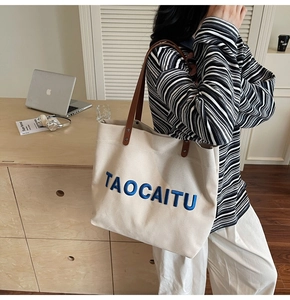 Spacious canvas tote bag with leather handles shown on shoulder for daily commute