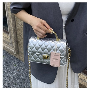 Detail of silver quilted leather bag with gold twist lock and metal chain strap