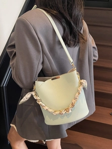 Sac seau en cuir vert clair avec bandoulière chaîne en métal et foulard porté en bandoulière